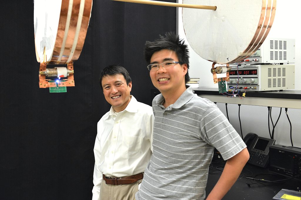 Professor Shanhui Fan (left) and graduate student Sid Assawaworrarit with the device they used to show wireless charging of a moving object. (Photo: Mark Shwartz/Stanford University